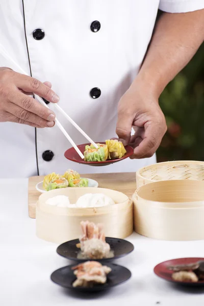 Шеф-повар с палочками держит китайскую клецку — стоковое фото