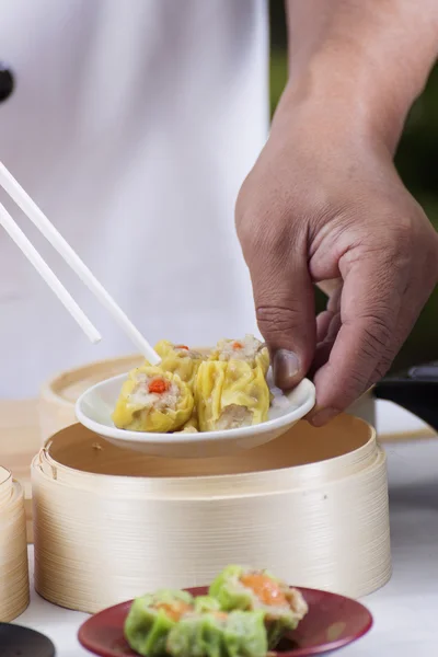 Шеф-повар с палочками держит китайскую клецку — стоковое фото
