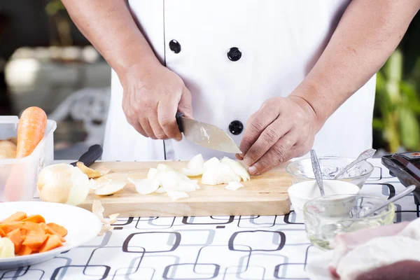 Chef cutting the onion on a wooden board — Stock Photo, Image