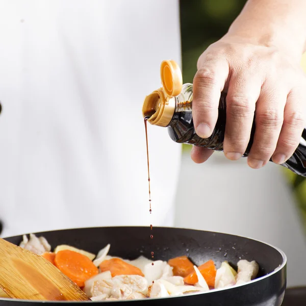 Chef derramando molho shoyu para a panela para cozinhar porco japonês cu — Fotografia de Stock