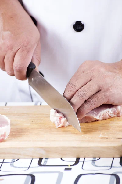 Chef cutting raw pork on wooden board — Stock Photo, Image