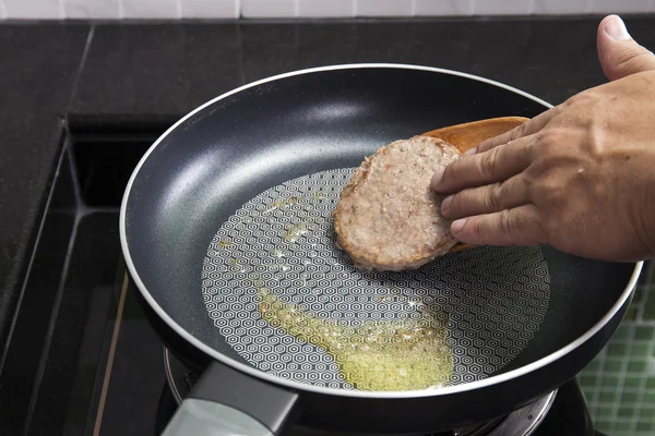 Шеф-повар готовит гамбургер на сковороде — стоковое фото