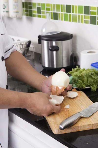 Chef pelando cebolla para hacer hamburguesa — Foto de Stock