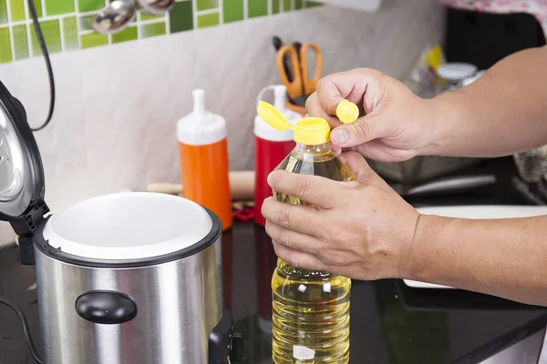 Chef open cap of vegetable oil — Stock Photo, Image