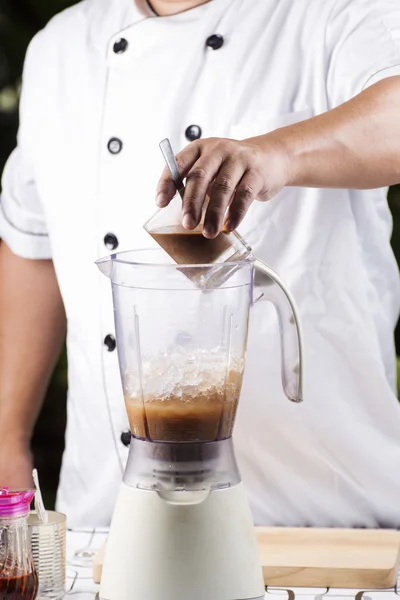 Chef putting coffee to blender