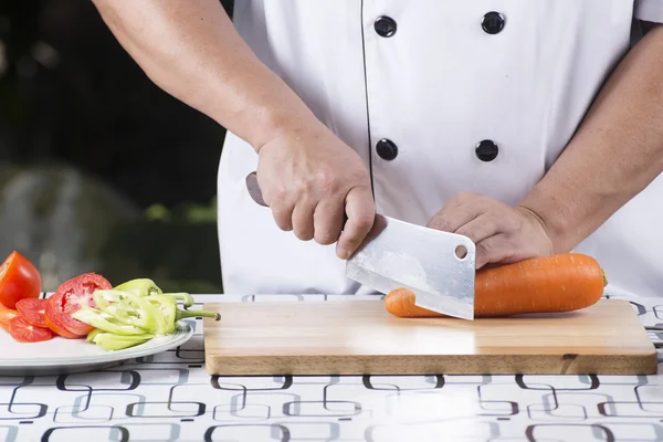 Koch schneidet Möhre — Stockfoto