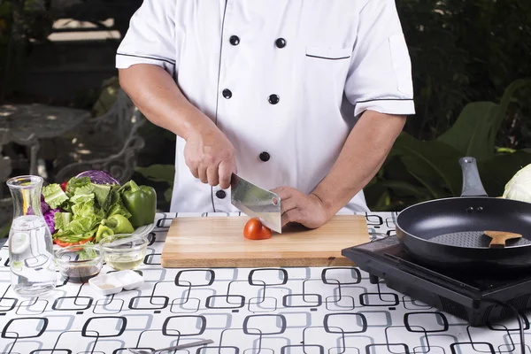 Chef slice tomato on wooden broad — Stock Photo, Image