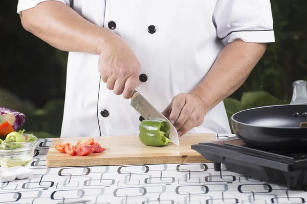 Шеф-кухар, який ріже зелений болгарський перець — стокове фото