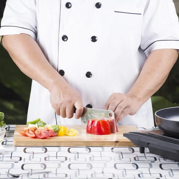 Köksmästare skära röd paprika — Stockfoto