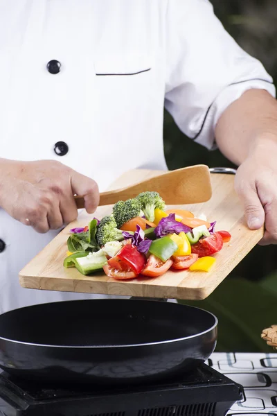 Szef kuchni, stawianie warzywa na patelni — Zdjęcie stockowe