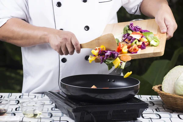 Chef colocando vegetais na panela — Fotografia de Stock