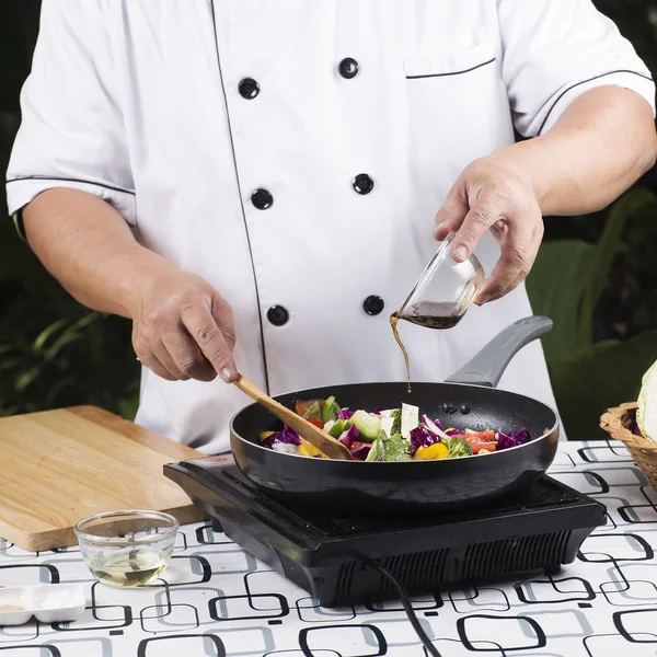 Chef-kok gieten saus aan de pan — Stockfoto