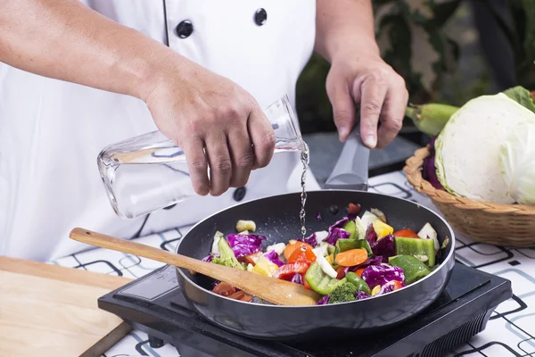 Chef pouring soup to the pan — Stock Photo, Image