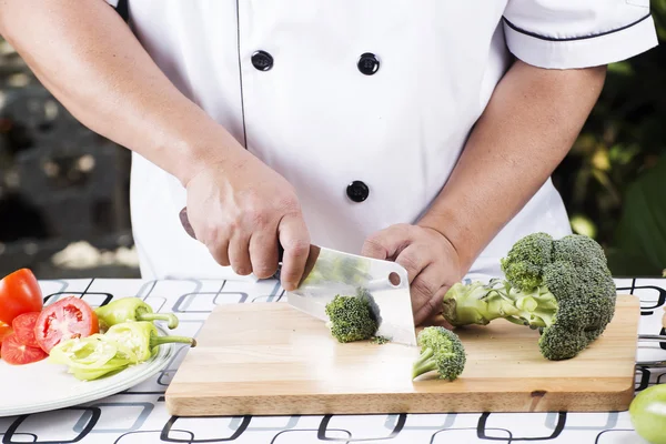 Kocken skär broccoli — Stockfoto