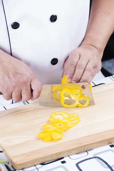 Шеф-повар режет желтый перец — стоковое фото