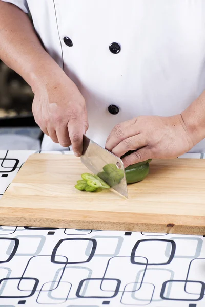 Шеф-повар режет зеленый перец — стоковое фото
