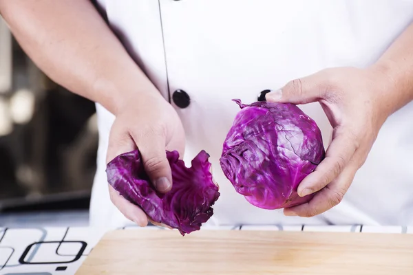 Шеф-повар расщепил лист фиолетовой капусты — стоковое фото