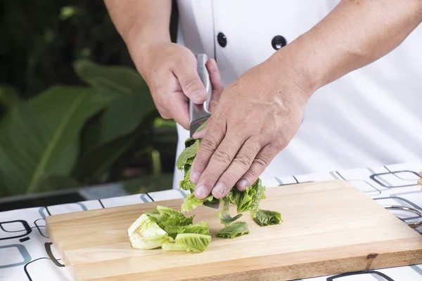 Шеф-кухар тримає скибочки салату на ножі — стокове фото
