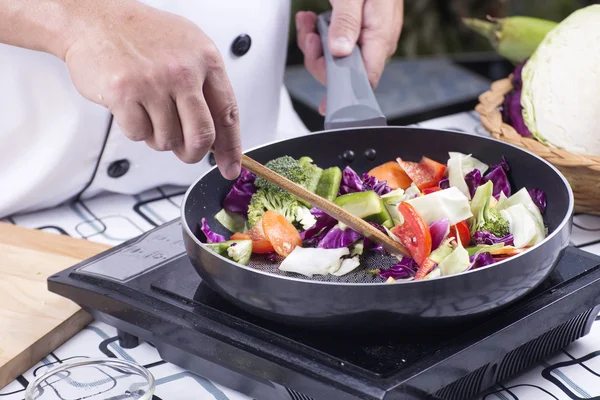 Chef cuisinier agiter les légumes frits — Photo