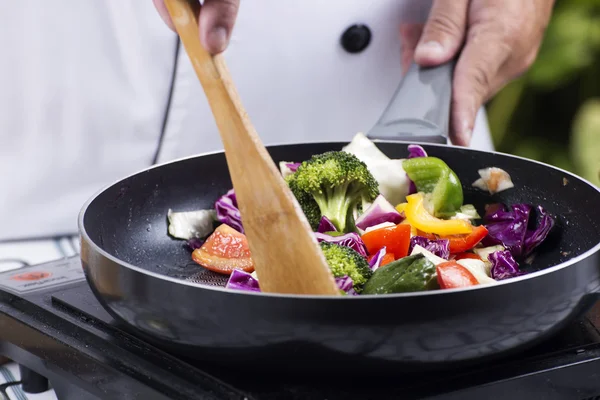 Küchenchef rührt gebratenes Gemüse um — Stockfoto