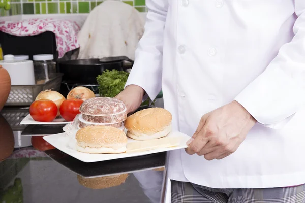 Шеф-повар представляет ингредиенты или гамбургер — стоковое фото