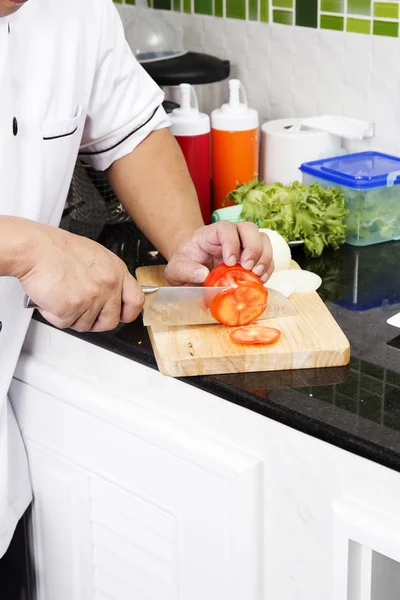 Mãos de Chef cortando Tomate — Fotografia de Stock