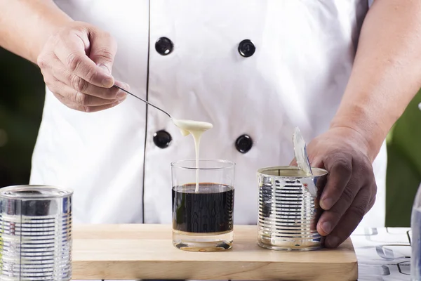 Chef putting condensed milk to Hot coffee — Stock Photo, Image