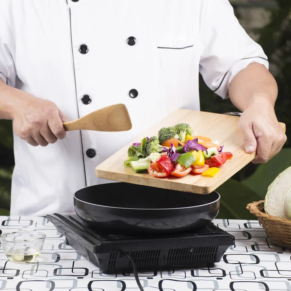 Chef colocando vegetais na panela — Fotografia de Stock