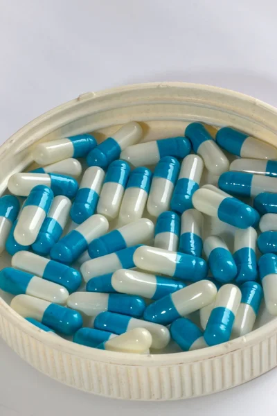 Niebieski biały kapsułki leku na białym tle — Zdjęcie stockowe