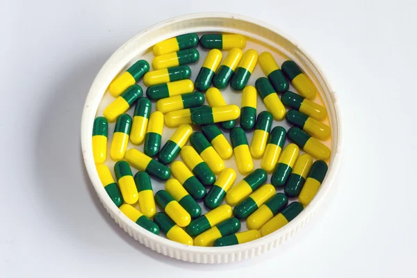 Зеленые желтые капсулы препарата изолированы — стоковое фото