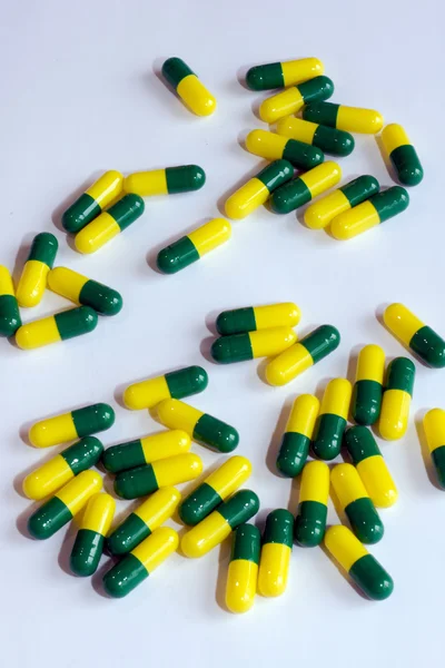 Zielony żółty kapsułki leku na białym tle — Zdjęcie stockowe