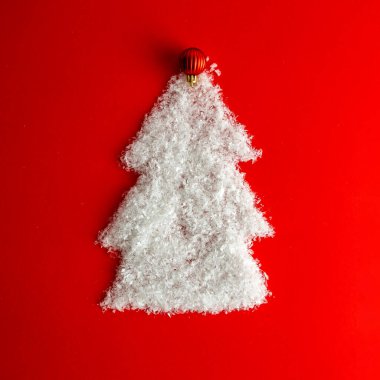 Kırmızı zemin üzerinde kardan yapılmış el yapımı Noel ağacı. Yeni yıl konsepti.