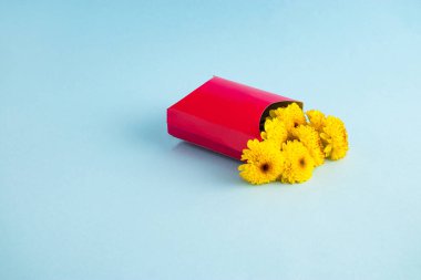 Patates kızartması kutusunda sarı çiçekli yaratıcı kompozisyon. Sevgililer Günü ya da kadınlar için arka plan tasarımı.