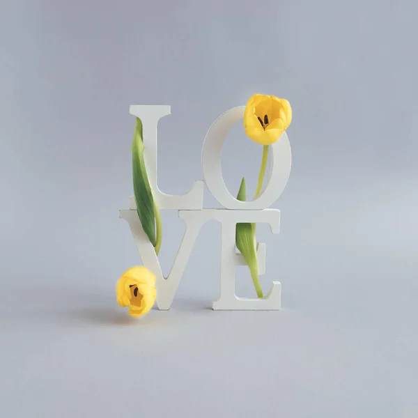 Composition with the letters LOVE and flowers. Nature love concept. Mother\'s day or Valentines idea.