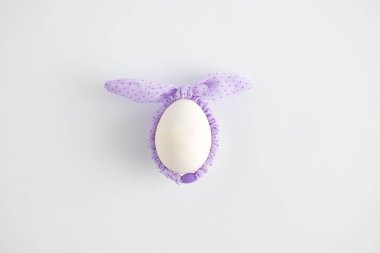 Paskalya yumurtası ve beyaz arka planda renkli saç bantları olan yaratıcı bir kompozisyon. Asgari Paskalya ya da gıda konsepti. Düz yatıyordu.