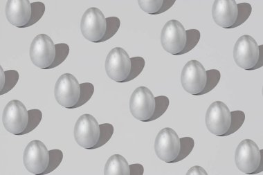 Gri bir arka planda gümüş paskalya yumurtasından yapılmış desen. Minimum tatil konsepti. Düz yatış, üst görünüm.