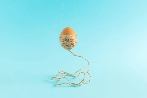 Huevo Pascua Con Una Cuerda Marrón Levita Aire Sobre Fondo — Foto de Stock