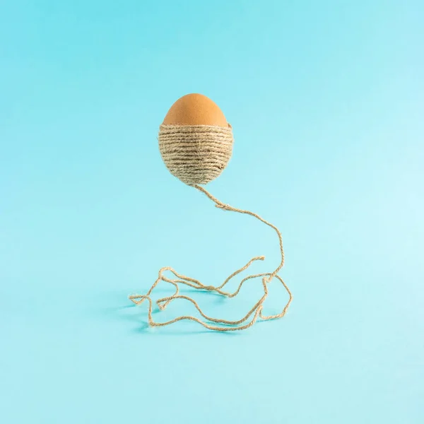 Huevo Pascua Con Una Cuerda Marrón Levita Aire Sobre Fondo — Foto de Stock