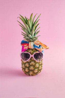 Güneş gözlüklü, eşarplı, şık meyveli Pineapple hipster ile yaratıcı bir yaz fikri. Minimum tropikal konsept. Sanat modasına uygun tatil konsepti. Yaz mevsimi renk havası, ananas meyvesi