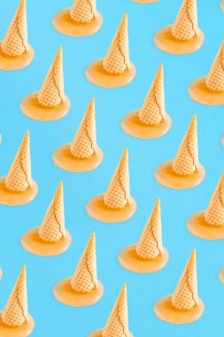 Yaz şablonu arka planında açık mavi arka planda eriyen dondurma külahı ve portakallı. Sağlıklı beslenme ya da doğa konsepti. En az yaz yemeği..