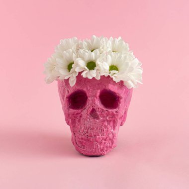 Pembe arka planda çiçekli bir kafatası. Cadılar Bayramı yaratıcı moda aşkı konsepti.