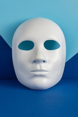 Mavi arka plana karşı yaratıcı yüz maskesi. Asgari Tatil sezonu kavramı.