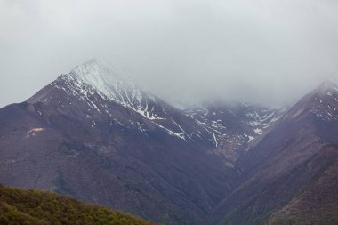 Karla kaplı tepeler ve karanlık kayalar