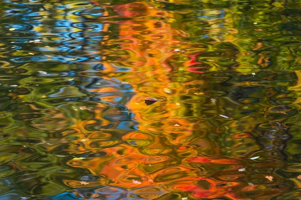 Superficie multicolor del agua y reflejo del follaje otoñal — Foto de Stock