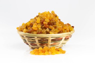 Hasır bir kasedeki kuru üzümler beyazda izole edilmiş.