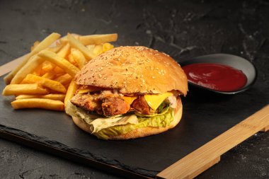 Köfteli, peynirli, siyah arka planda sebzeli ızgara burger. Metin için boş alan