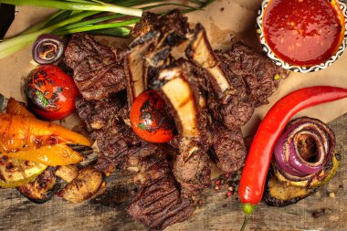 Çok güzel ızgara kuzu pirzola biftek, orta pişmiş ve ahşap servis tahtasında ızgara sebze..