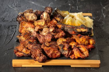 Kırsal bir tahtada siyah arka planda ızgara gurme eti seçimi..