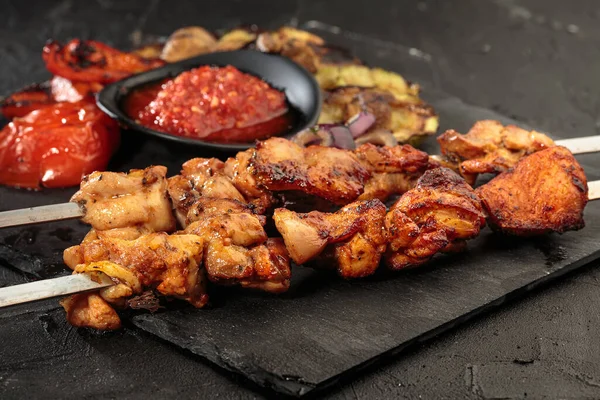 Shashlik ou shish kebab preparando-se em churrasqueira sobre carvão quente. Pedaços grelhados de carne de porco em espetos metálicos. — Fotografia de Stock