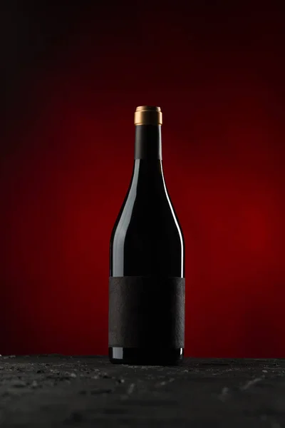 Botella de vino sobre fondo rojo — Foto de Stock